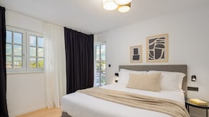 A bedroom with a bed, a nightstand, a window with curtains, and two wall-mounted artworks. - Villa Verde Razanj With Heated Pool (Rogoznica)