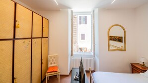 A room with a bed, a desk, a chair, a wardrobe, a window, and a mirror. - Ernesta 3BR Lovely Home by The Spanish Steps (Roma)
