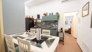 A modern kitchen with a dining table, chairs, and a visible kitchen counter. - Ernesta 3BR Lovely Home by The Spanish Steps (Roma)
