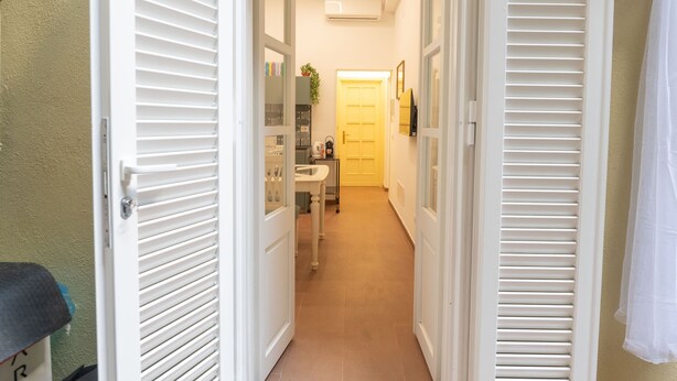A narrow hallway with white doors, a sink, and a cart. - Ernesta 3BR Lovely Home by The Spanish Steps (Roma)