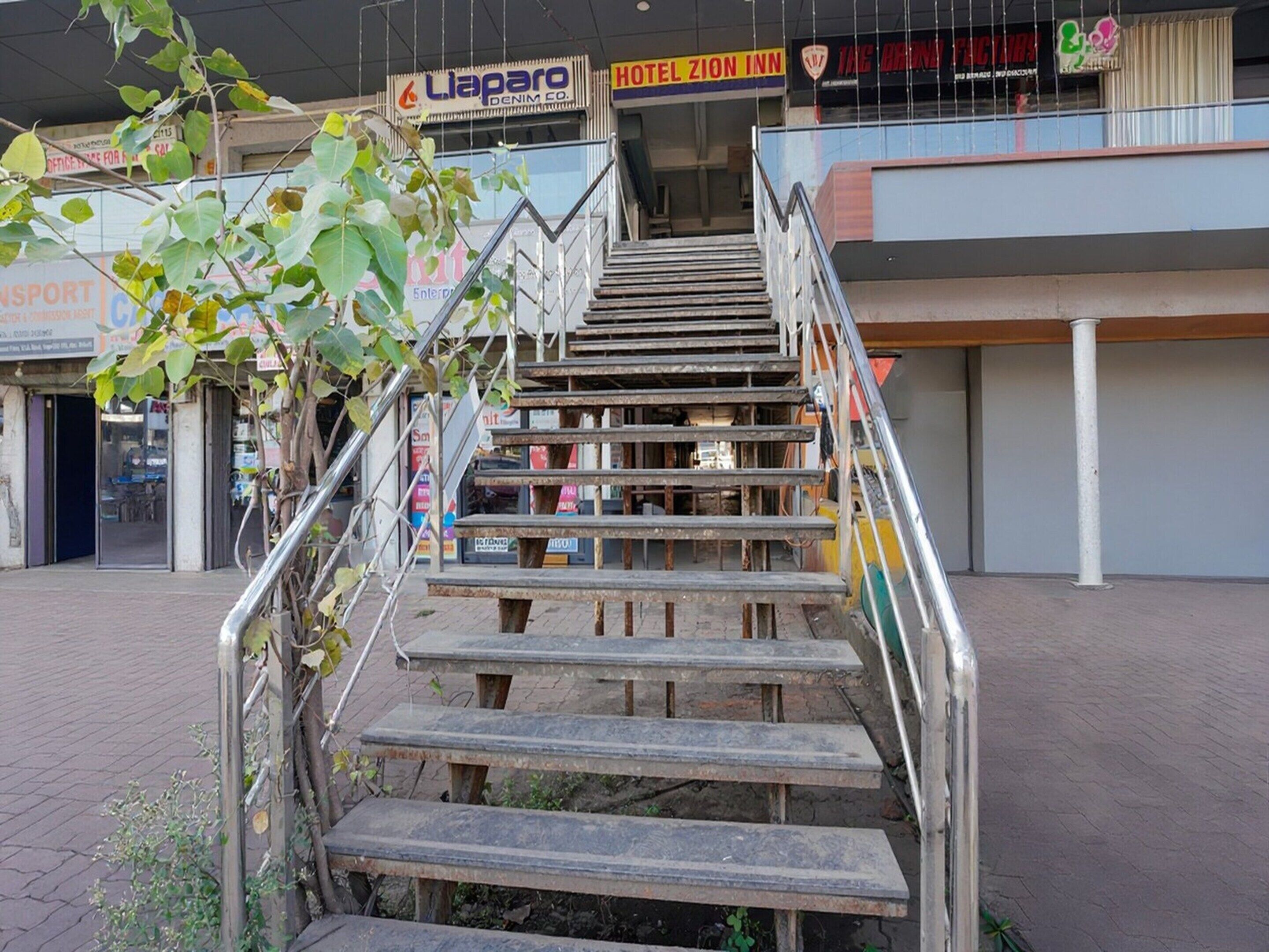 A staircase leading to an upper floor of a building with a sign for Hotel Zion Inn above it.