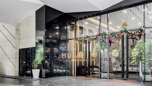 A modern building with glass doors, a potted plant, and a Christmas decoration. - Royce Residences KLCC by CREMES KL (Kuala Lumpur)