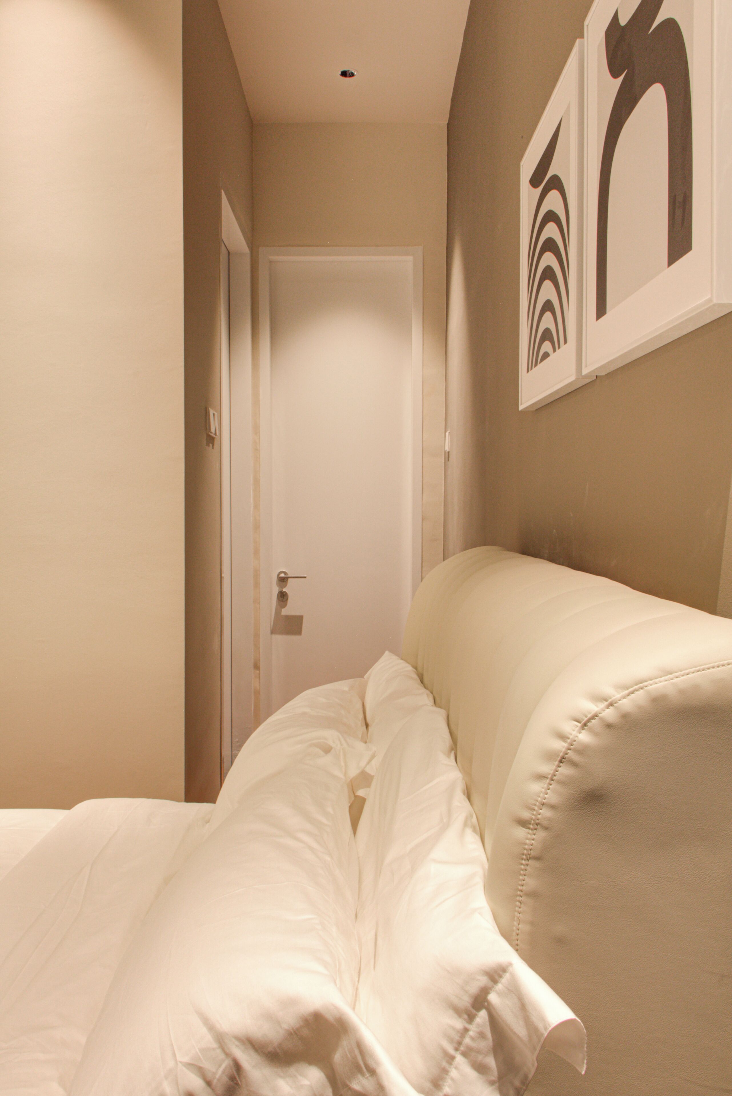 Un dormitorio con cama, puerta y decoración en la pared.