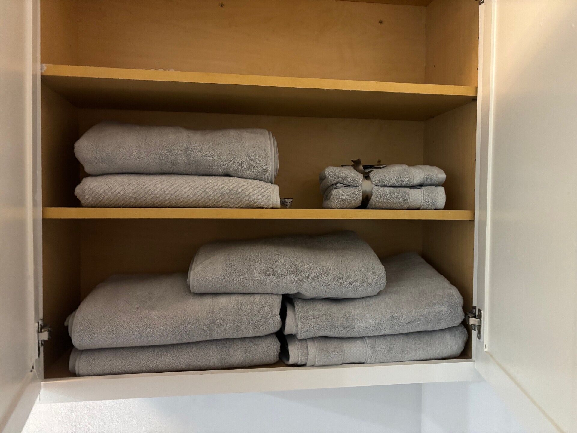 A wardrobe with multiple shelves holding folded towels.