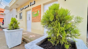 A building with a sign reading 'Casa Mama Fant' and two potted plants in front.