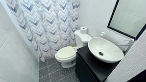A bathroom with a toilet, a sink, and a shower curtain.
