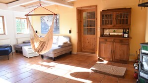 Um quarto com uma cadeira suspensa, um sofá, um armário e um radiador.