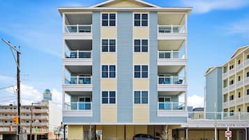 A multi-story residential building with balconies, a garage, and a visible storefront.