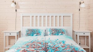 A bedroom with a wooden headboard, two bedside tables, and a bed with a floral bedspread. - Comfortable Holiday Home , Summer Pool (Rewal)
