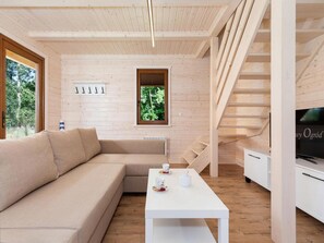 A modern interior with a wooden floor, a beige sectional sofa, a white coffee table, and a television on a stand. - Comfortable Holiday Home , Summer Pool (Rewal)