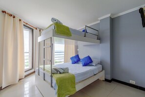 A bunk bed room with a view of the outdoors through a window. - Oceanfront Triplex Penthouse: 4 Bedrooms (Cartagena de Indias)