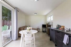 Eine moderne Küche mit Essbereich, einer Couch und einem Fernseher.