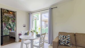 Een woonkamer met een bank en een eethoek met een tafel en stoelen.