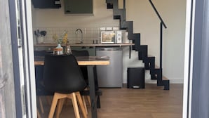 Ett modernt kök med mikrovågsugn, diskho och en matplats med stolar och ett bord.