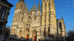 Eine historische Kathedrale mit aufwendiger Steinmetarbeit, großen Bogenportalen und einem hohen Turm.