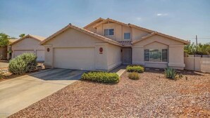 A single-story house with a garage, a front porch, and a landscaped driveway. - Aviation Retreat +Pool +Sunset Views (Oro Valley)
