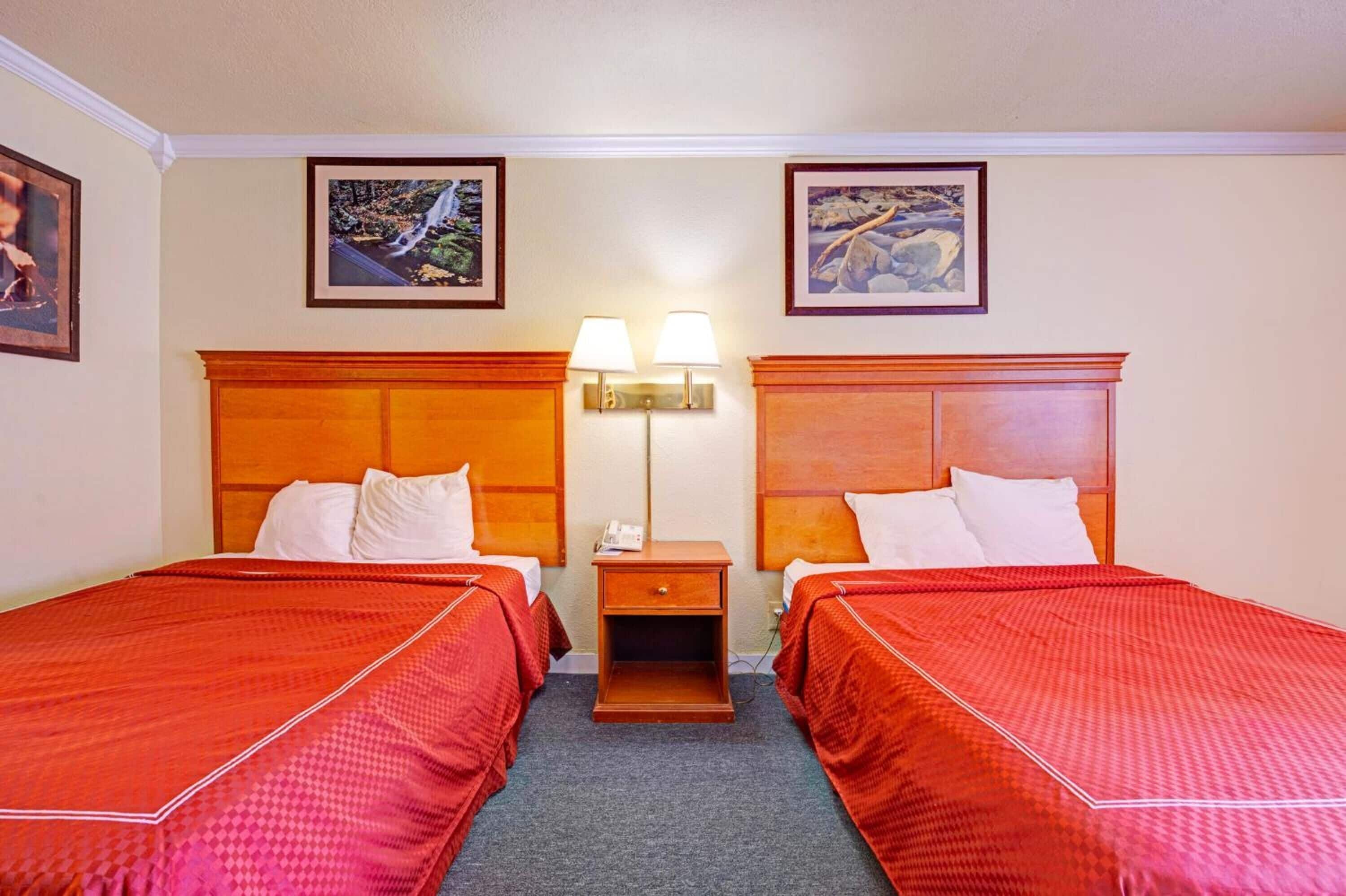 Unwind in a cozy double-queen room with warm lighting.