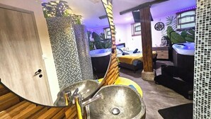 A bathroom with a large stone sink, wooden accents, and a tropical-themed wall. - Jacuzzi relaxation near Colmar (Bergheim)