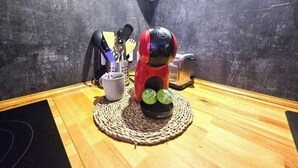 A kitchen area with a coffee machine, a kettle, and a set of utensils on the counter. - Jacuzzi relaxation near Colmar (Bergheim)