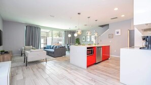 A modern apartment with a living room, dining area, and kitchen. - Premium Location Near Disney with Pool at Le Reve (Kissimmee)