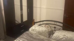A bedroom with a bed, a wardrobe, and a door. - Room-cozy Private Room With Modern Ameni (Dagenham)