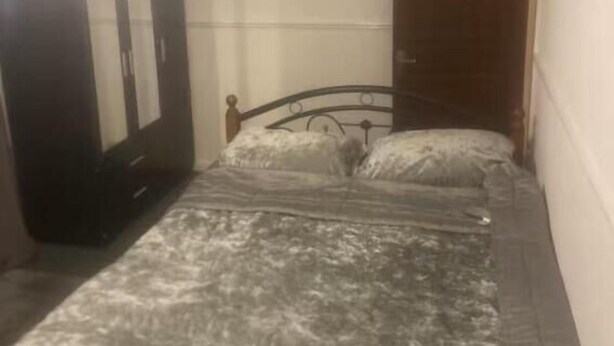 A bedroom with a bed, a wardrobe, and a door. - Room-cozy Private Room With Modern Ameni (Dagenham)
