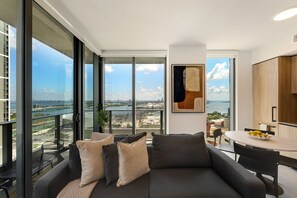 Un soggiorno moderno con un divano, un tavolo da pranzo e vista sulla città e sull'acqua.