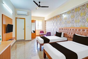 A hotel room with two beds, a television, a desk, and a reception area. - Premium Stays by Hotel Trubell Electronic City (Anekal)