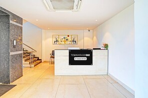 A reception desk with a sign reading 'TOWNHOUSE OAK Company Serviced.' - Premium Stays by Hotel Trubell Electronic City (Anekal)