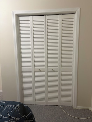 Ein weißer Schrank mit zwei Türen und Teppichboden.