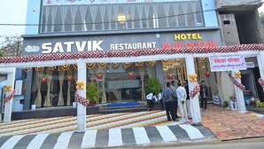 A multi-story building with a sign for 'Hotel Blue Ocean' and 'Satvik Restaurant' on the ground floor.