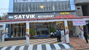 A multi-story building with a sign for 'Hotel Blue Ocean' and 'Satvik Restaurant' on the ground floor.