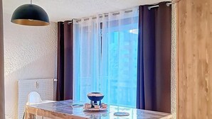 Ein Essbereich mit einem Holztisch, Stühlen, einer Schüssel und einer hängenden Leuchte.