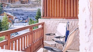 Ein Balkon mit Blick auf Holzhäuser und eine Baustelle.