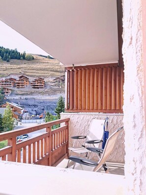 Ein Balkon mit Blick auf Holzhäuser und eine Baustelle.