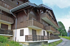A multi-story wooden building with balconies and a white lower level. - Ground floor, balcony, 26m², Les Gets (Les Gets)