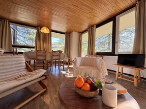 A spacious living room with a wooden ceiling, a sofa, a dining table with chairs, a television on a stand, and a fruit bowl on a coffee table. - 300m from shops, 3rd floor, balcony, ski locker, 60m², Vars (Vars)