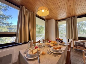 A dining table set with plates, glasses, and food, with a view of trees through large windows. - 300m from shops, 3rd floor, balcony, ski locker, 60m², Vars (Vars)