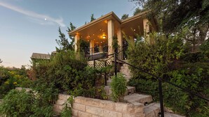 A building with a covered porch, stone steps, and a railing.