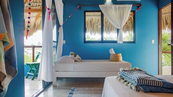 Una habitación con una cama, una ventana con cortinas, una mesita y una silla.