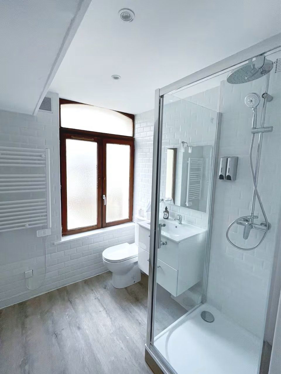 Une salle de bain moderne avec une douche à parois de verre, des toilettes et un lavabo.