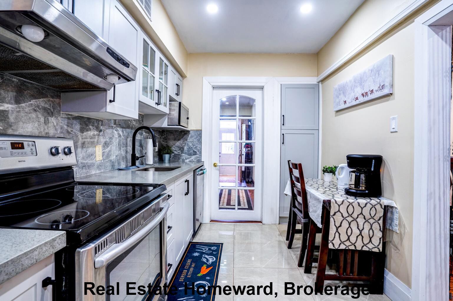 A kitchen with a stove, sink, and cabinets, a dining area with a table and chairs, and a door leading to a balcony.