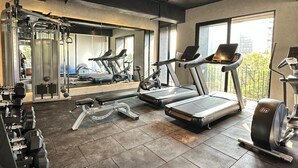 Ein Fitnessstudio mit Laufbändern, Kraftgeräten und Kurzhanteln.