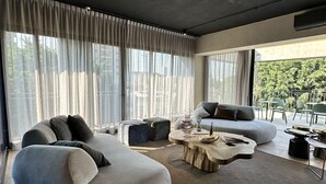 Ein modernes Wohnzimmer mit einer großen Couch, einem Couchtisch und einem Essbereich.