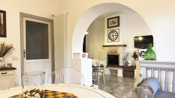 A dining area with a chessboard, a fireplace, and a television mounted on the wall. - Il Casale Sotto La Torre ***(Via del Colle 21, Torano di Borgorose) (Torano)