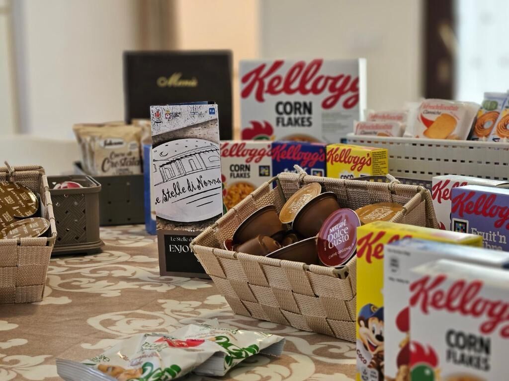 Een presentatie van diverse etenswaren, waaronder Kellogg's Corn Flakes, Nestle Dolce Gusto, en andere snacks.