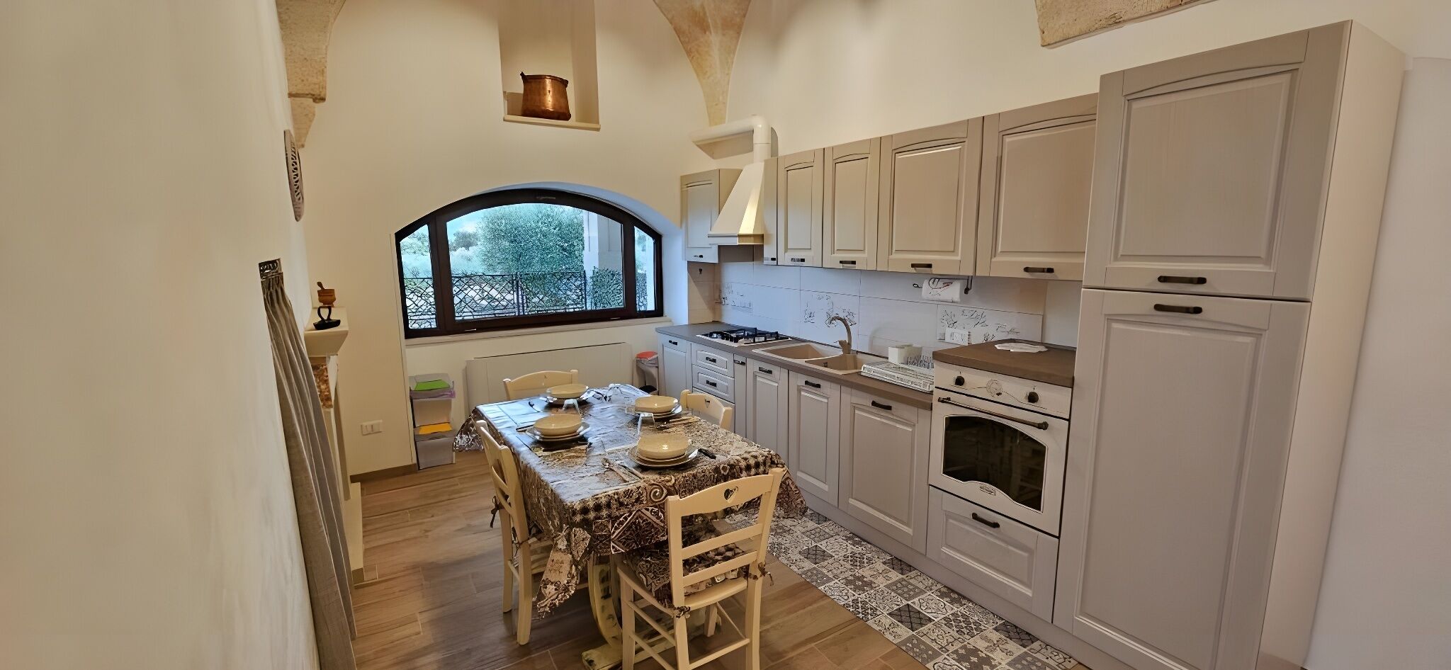 A kitchen with a dining table, cabinets, and a window.