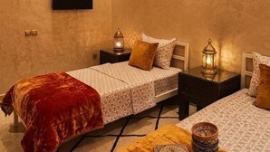 Una camera da letto con un letto, comodini, una TV e soprammobili.