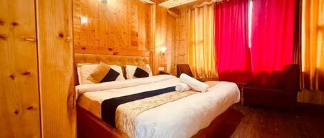 A wooden-paneled room with a bed, a nightstand, and a red curtain.