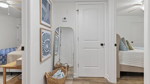Un dormitorio con cama, mesita de noche, silla y un calentador fijado a la pared.